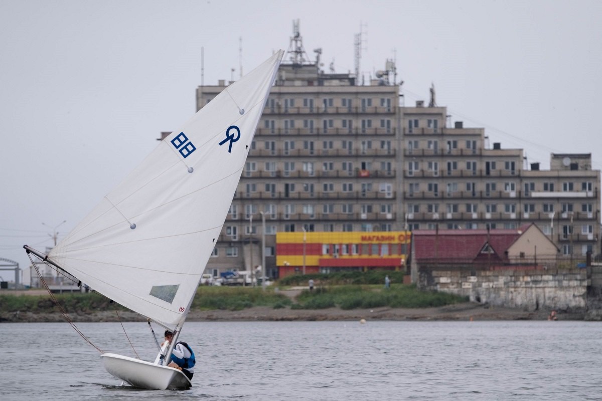 Regatta-Teilnehmer vor dem Hintergrund eines Hauses in Cholmsk