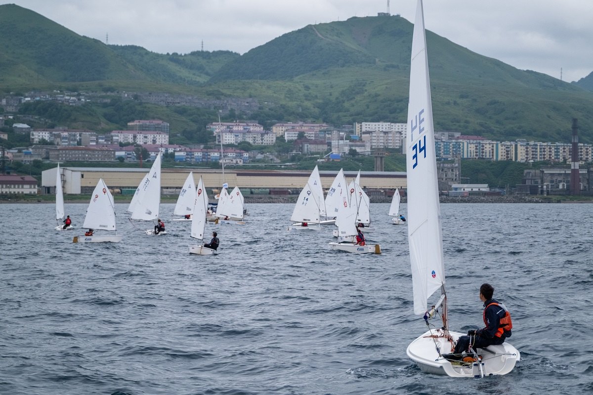 Regatta-Teilnehmer vor dem Hintergrund der Stadt Cholmsk