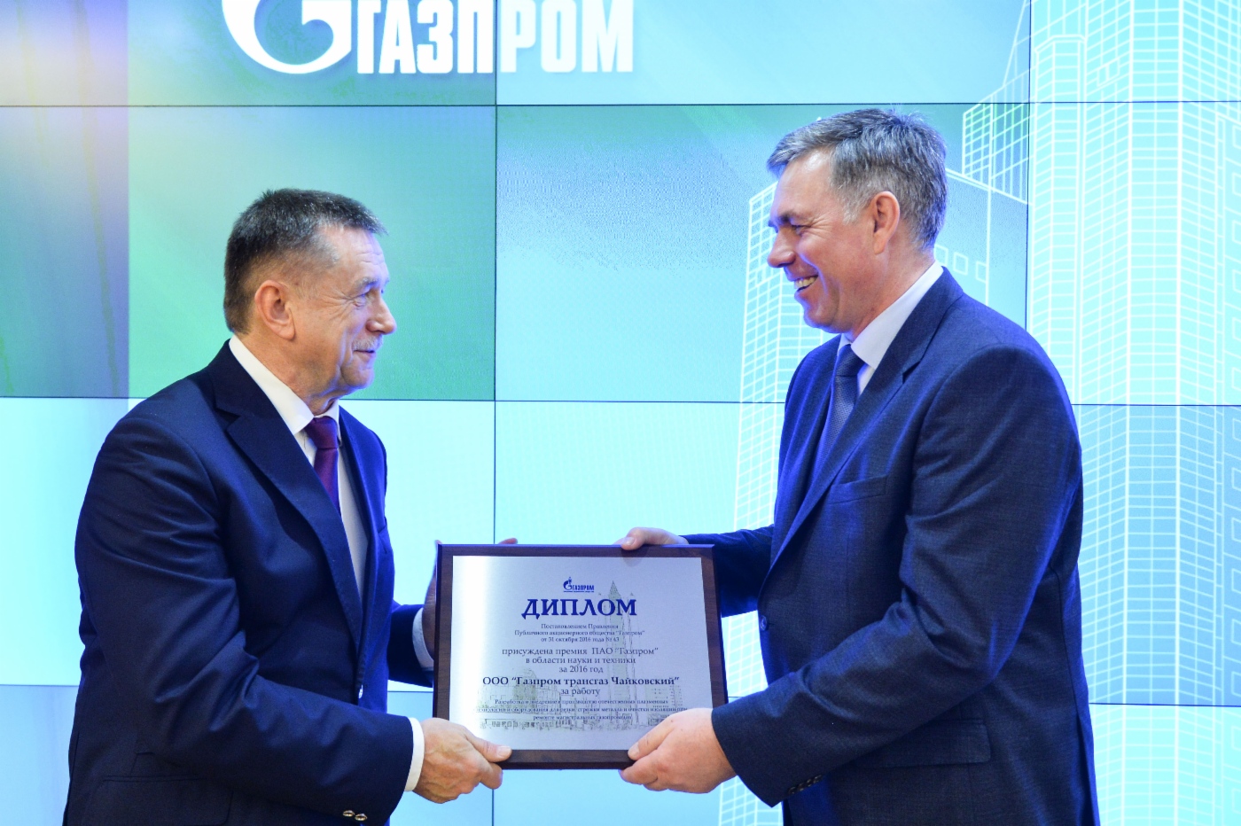 Sergey Khomyakov (links) überreicht Sergey Suslikov, Generaldirektor der Gazprom Transgaz Tchaikovsky (rechts), einen Preis