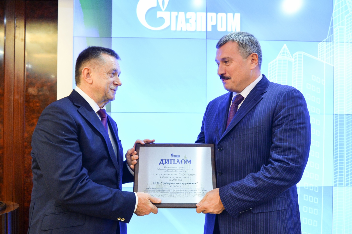 Sergey Khomyakov (links) überreicht Dmitry Doev, Generaldirektor der Gazprom Tsentrremont (rechts), einen Preis