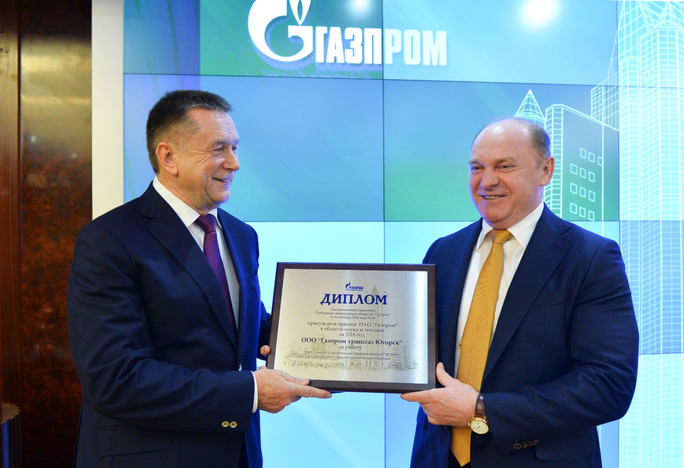 Sergey Khomyakov (links) überreicht Pyotr Sozonov, Generaldirektor der Gazprom Transgaz Yugors (rechts), einen Preis