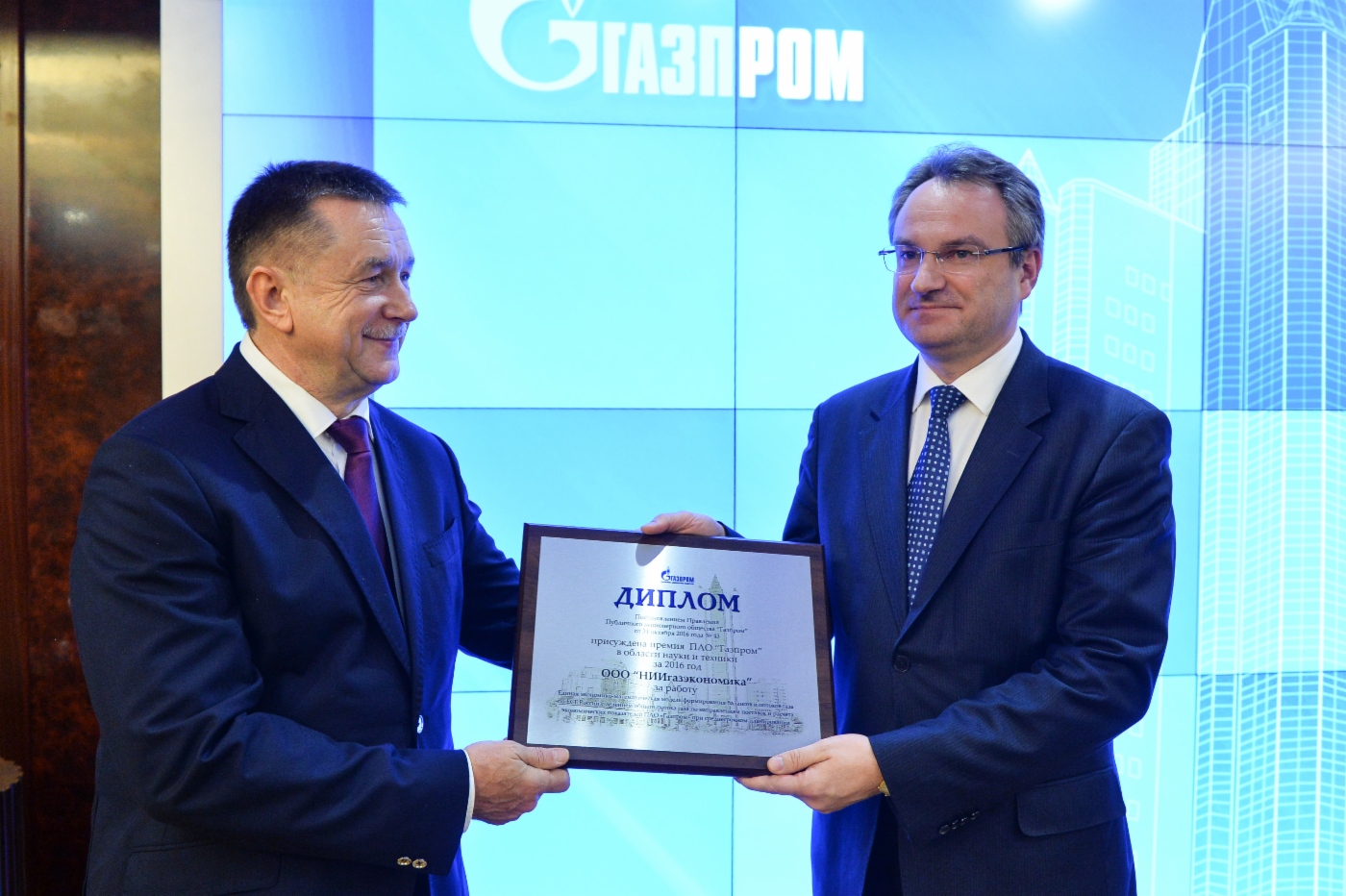 Sergey Khomyakov (links) überreicht Nikolai Kislenko, Generaldirektor der NIIgazeconomika (rechts), einen Preis
