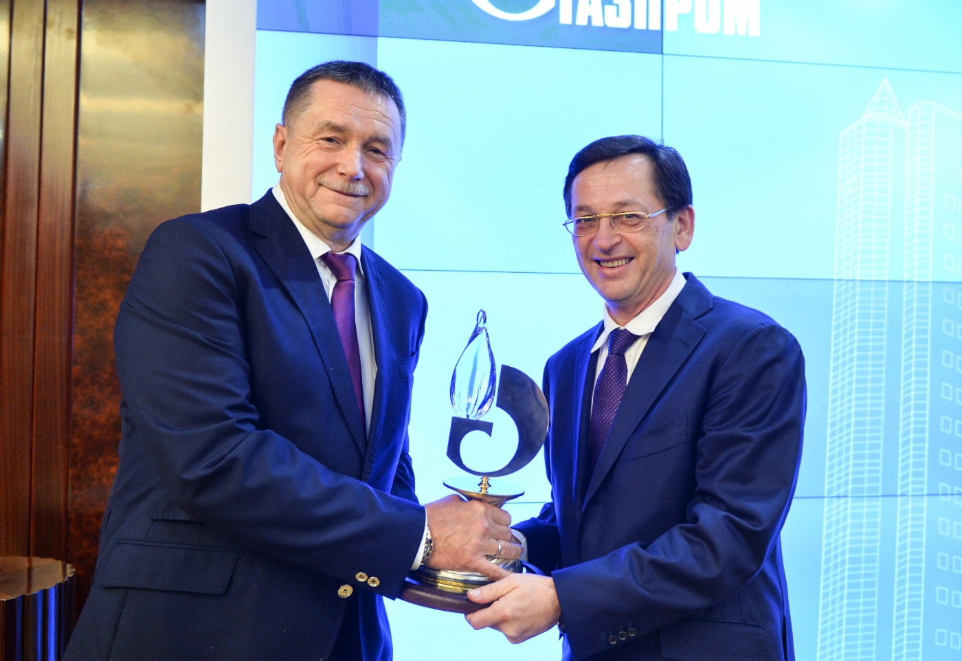 Sergey Khomyakov (links) überreicht dem Sieger des Wettbewerbs Sergey Shilov, Generaldirektor der Gazprom UGS (rechts), einen Preis