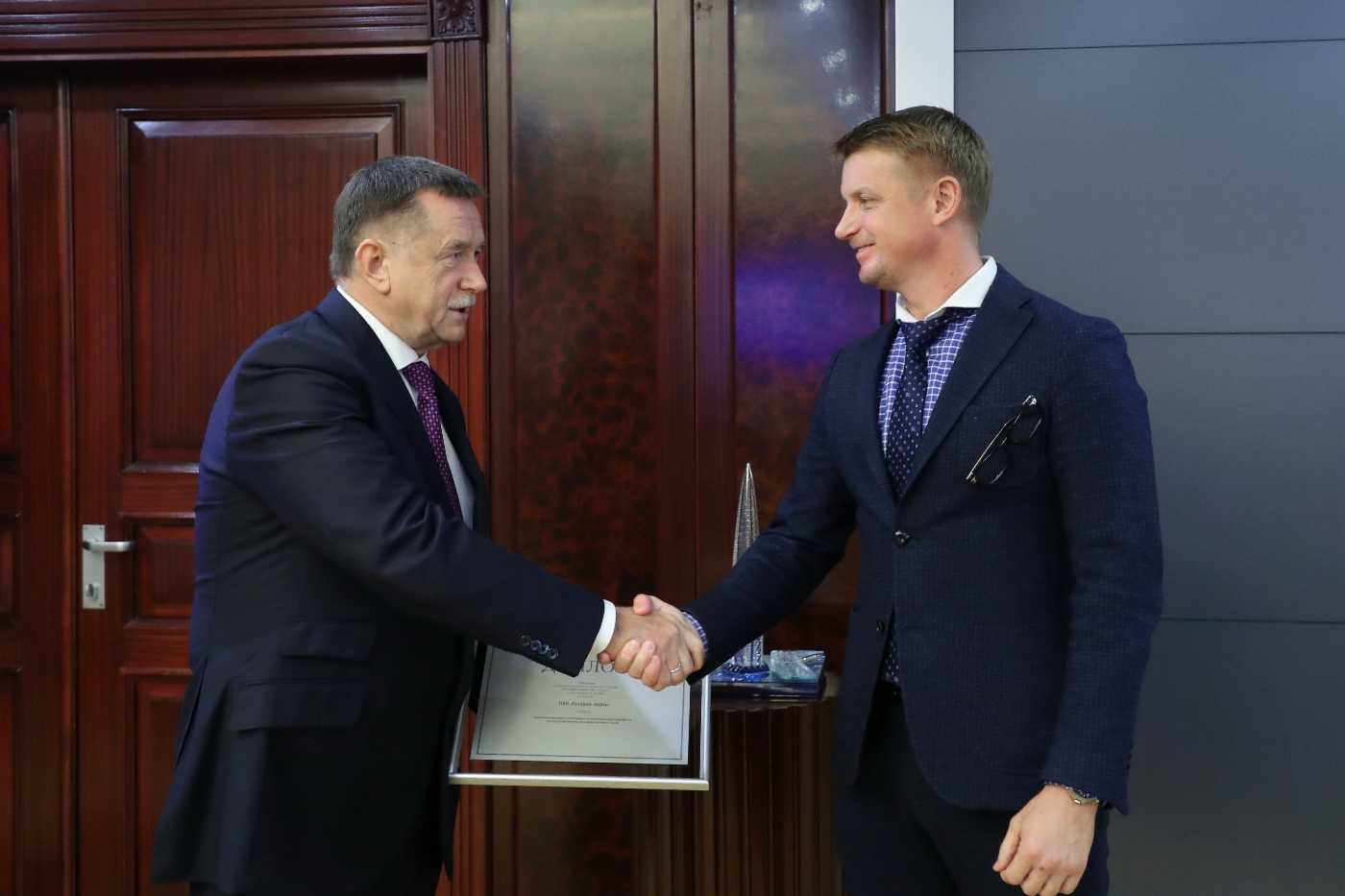 Sergey Khomyakov gratulierte dem Leiter der Unterabteilung für Erdölverarbeitung bei der Gazprom Neft, Mikhail Antonov, zur Auszeichnung