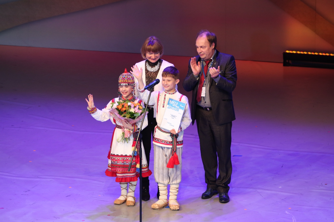 Juroren Olga Yudakhina und Ivan Zhiganov, Kinder-Folkloreensemble Schurampus (OOO Gazprom Transgaz Nizhny Novgorod) Preisträger des 1. Grades in der Kategorie Folklore